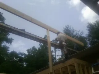 Carpenter setting a ridge beam over a new addition frame — Ice Dam Removal by Roofing Brothers in Bunnell