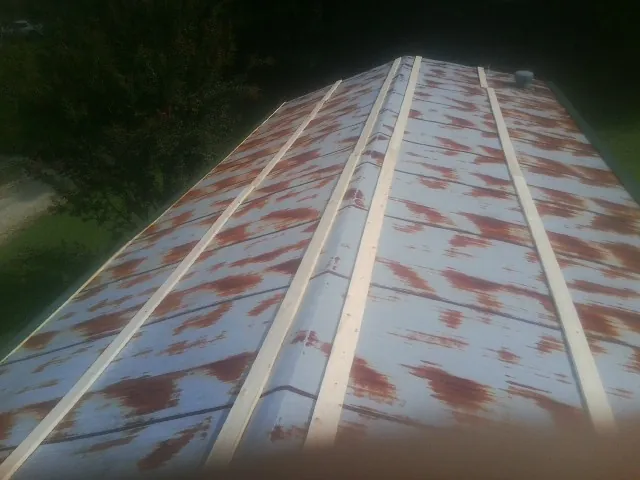 Rusted metal roof panels with new wood purlins before replacement — Storm Damage Roof Repair in Bunnell by Roofing Brothers
