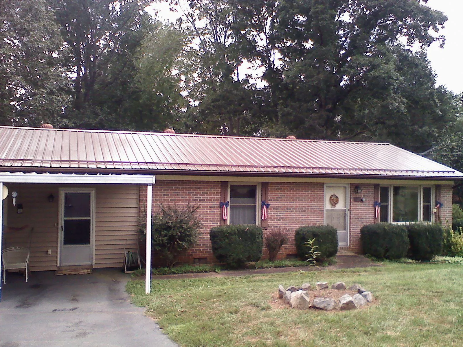 Bronze metal roof and carport on a brick ranch home — Roof Repair work by our crew in Bunnell