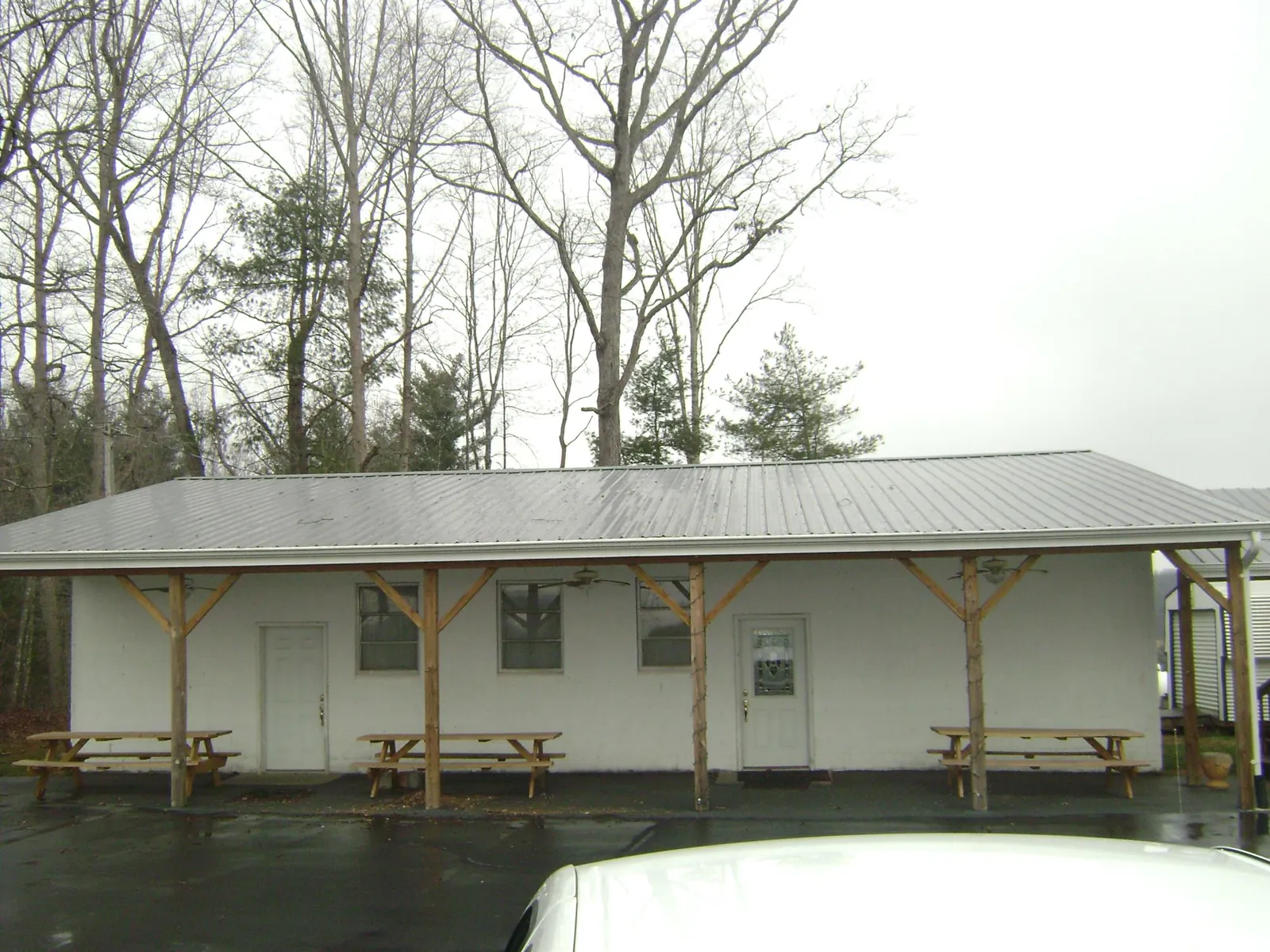 Gray metal roof over a block building with a timber post porch in Bunnell